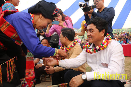 Những người cao tuổi có uy tín trong bản buộc chỉ cổ tay cầu may mắn cho mọi người.(Tết té nước của người Lào tại xã Núa Ngam năm 2018) .