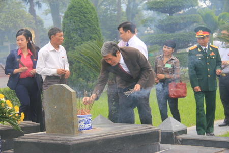 Đồng chí Đinh Thế Huynh ( áo nâu )  - Bí thư Trung ương Đảng, Trưởng Ban Tuyên giáo Trung ương thắp hương tại phần mộ các Liệt sỹ