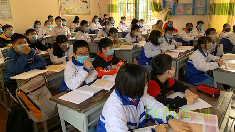 Các em học sinh đeo khẩu trang y tế được phát trong lớp học.