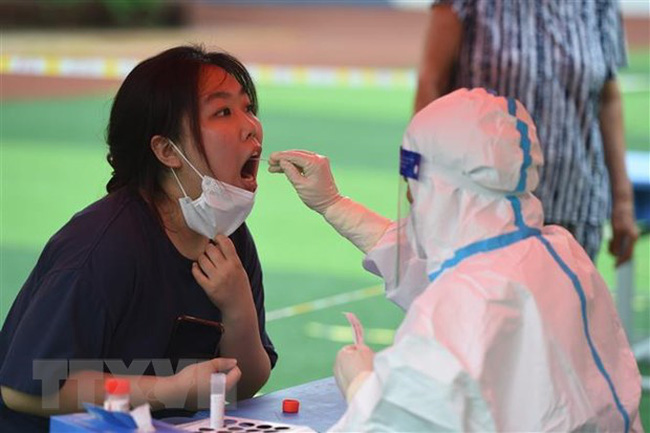 Nhân viên y tế lấy mẫu xét nghiệm COVID-19 cho người dân tại tỉnh An Huy, Trung Quốc ngày 16/7/2022. (Ảnh: THX/TTXVN)